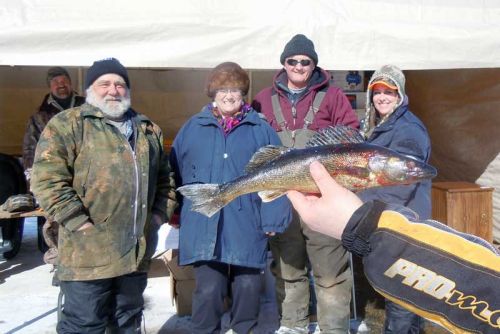 l-r Wilf and Debbie Deline and newbie trapper Heather Hugh with Don Martin of Ardoch (third from left), the latter of who landed this pickerel at the 11th annual Big Gull Lake Fishing Derby